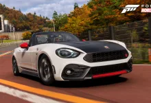 White and black 2017 Abarth 124 Spider driving on a road lined with golden autumn trees in Forza Horizon 6
