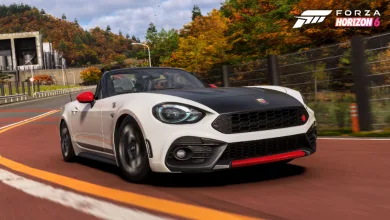 White and black 2017 Abarth 124 Spider driving on a road lined with golden autumn trees in Forza Horizon 6