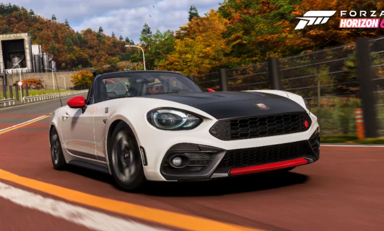White and black 2017 Abarth 124 Spider driving on a road lined with golden autumn trees in Forza Horizon 6