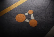 Orange connected-node symbol on a dark road surface with yellow lane markings