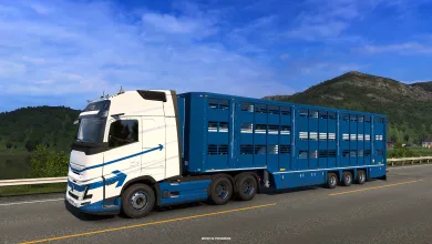 White truck pulling a blue livestock trailer on a mountain road in Euro Truck Simulator 2