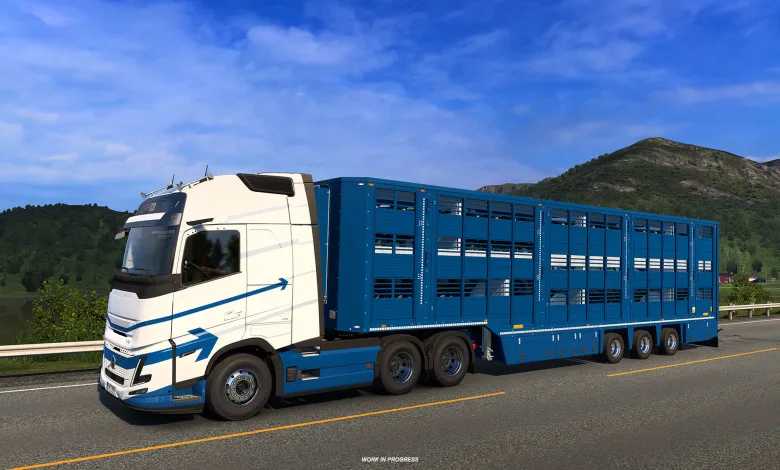 White truck pulling a blue livestock trailer on a mountain road in Euro Truck Simulator 2