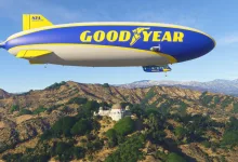 The Goodyear Blimp flies over a mountainous landscape in Microsoft Flight Simulator 2024