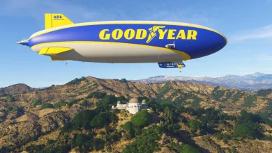 The Goodyear Blimp flies over a mountainous landscape in Microsoft Flight Simulator 2024