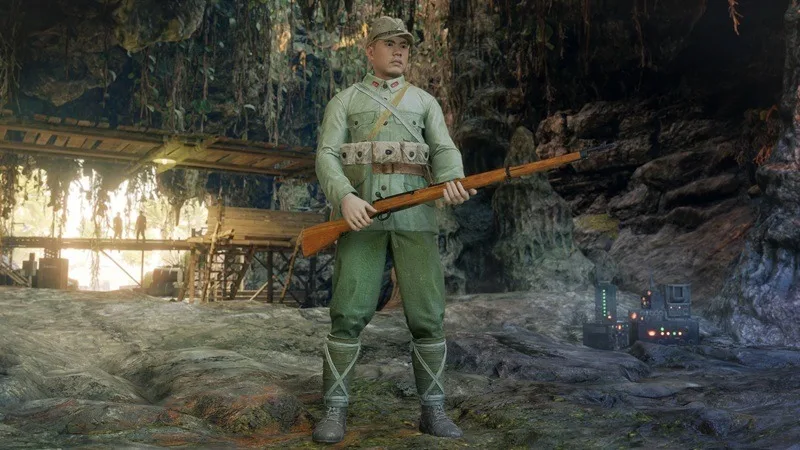 Kinshichi Kozuka standing with a rifle in a cave