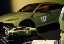 A 1:18 green Lamborghini replica marked 117 sits in front of a full-size green Lamborghini, with Master Chief armor visible at right