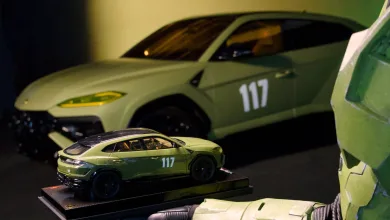 A 1:18 green Lamborghini replica marked 117 sits in front of a full-size green Lamborghini, with Master Chief armor visible at right