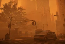 Orange dust storm obscures a New York street with buildings, traffic lights, and vehicles visible through the haze