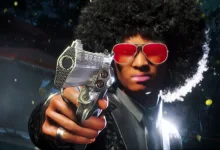 A contestant wearing red sunglasses aims a silver pistol in The Finals.