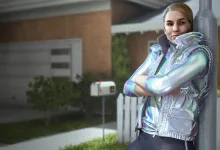 Contestant wearing a shiny silver puffer vest standing outside a suburban house in THE FINALS