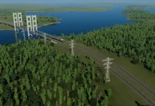 Cities: Skylines II landscape with a forested road, power lines, and a suspension bridge beside a lake