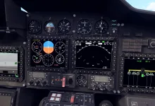 Cockpit instrument panel showing multifunction displays, radar symbology, and flight gauges