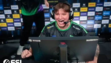 A Counter-Strike 2 esports player wearing a headset competes at a PC station in front of sponsor boards.