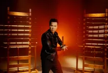 Donnie Yen stands between racks of swords in a Phantom Blade Zero promotional image.