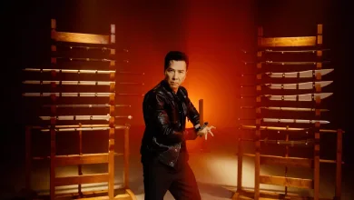 Donnie Yen stands between racks of swords in a Phantom Blade Zero promotional image.