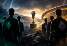 Two esports teams stand opposite each other while facing a championship trophy outside a large illuminated arena.