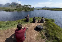 Members of the Euro Truck Simulator 2 map team sit beside a lake during their Ireland research trip.