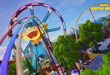 Fortnite amusement park area with looping roller coaster tracks, a large yellow sun-shaped decoration, trees, and buildings