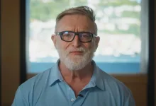 Gabe Newell wearing glasses and a blue shirt during a video message