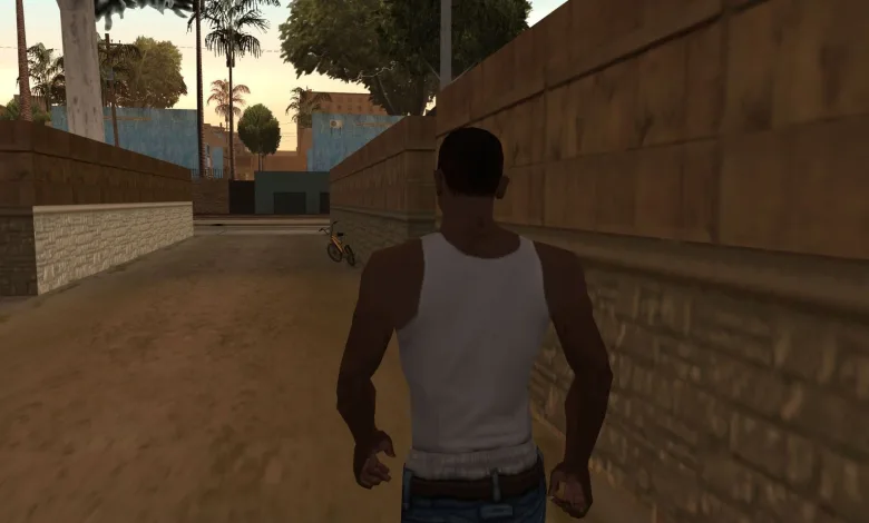 A character in a white tank top walks through an alley in Grand Theft Auto: San Andreas.