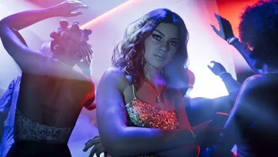 Grand Theft Auto VI character in a nightclub surrounded by dancing figures and colorful lights.