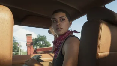 A woman wearing a red bandana sits inside a car with a city street visible through the windows.