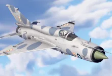 An Indian-marked fighter jet flies against a blue sky