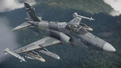 An Indonesian Hawk 209 jet flies over a forested landscape with missiles and other weapons mounted under its wings.