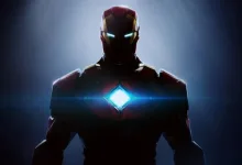 Iron Man stands in shadow with glowing blue eyes and a bright blue arc reactor.