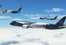 Several Lufthansa aircraft, including a dark blue jet marked 100, flying above the clouds