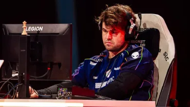 Magnus Carlsen wearing a Team Liquid jersey and headset at a chess esports station