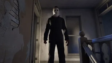 Michael Myers stands in a dim hallway in Halloween: The Game.