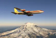 A Boeing 707-320C flies over a snow-covered mountain in Microsoft Flight Simulator 2024.