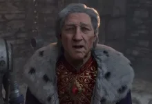 A gray-haired character in ornate red clothing and a fur-lined cloak stands in a stone setting in Oblivion Remastered.