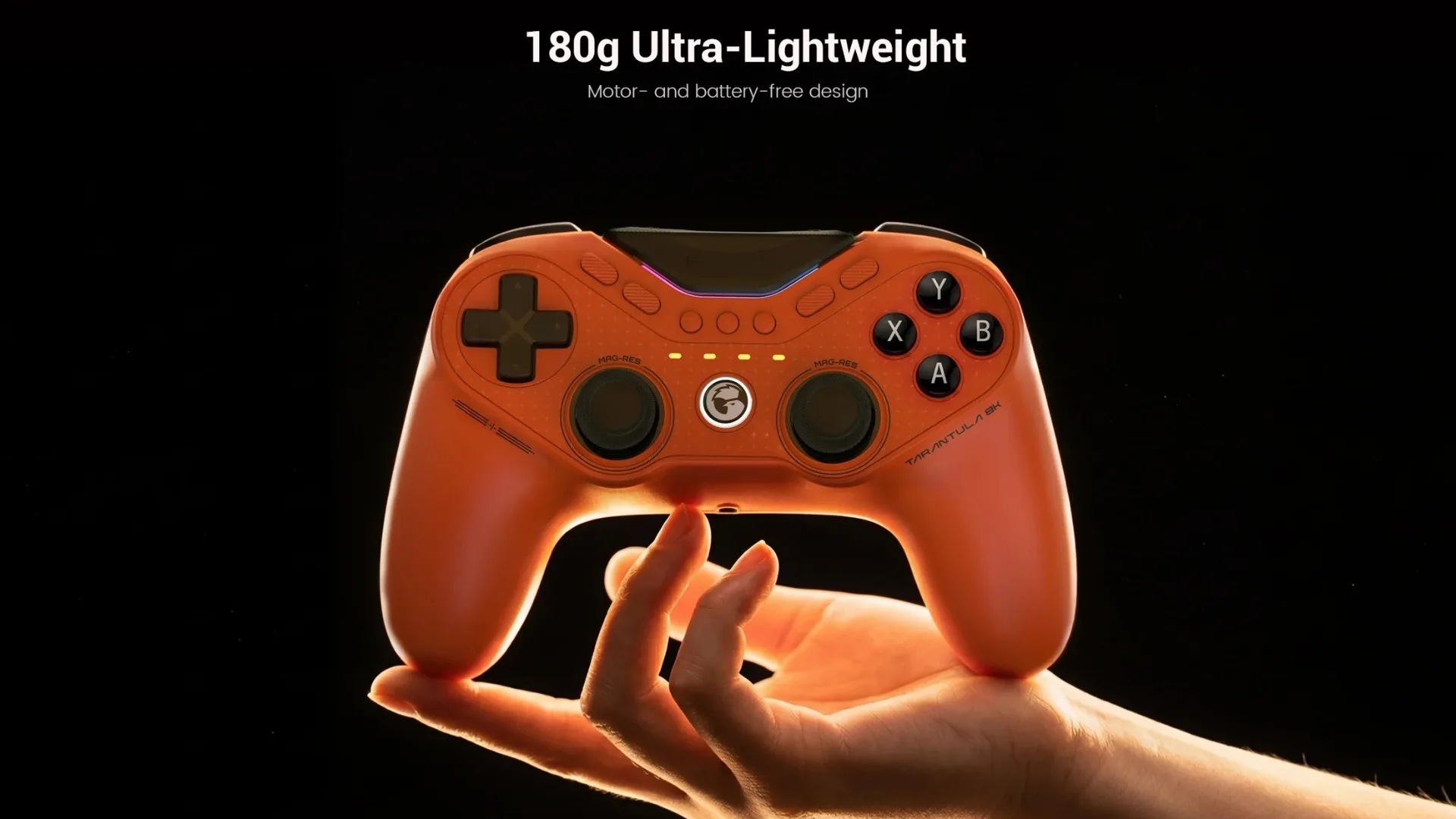 Orange Tarantula Pro controller resting above a hand