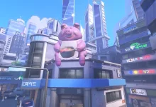 A bright city scene from Overwatch's Busan map with a large pink pig statue above the streets
