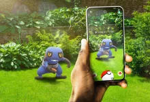 A Pokémon GO player encounters Croagunk in a garden using a smartphone