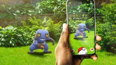 A Pokémon GO player encounters Croagunk in a garden using a smartphone