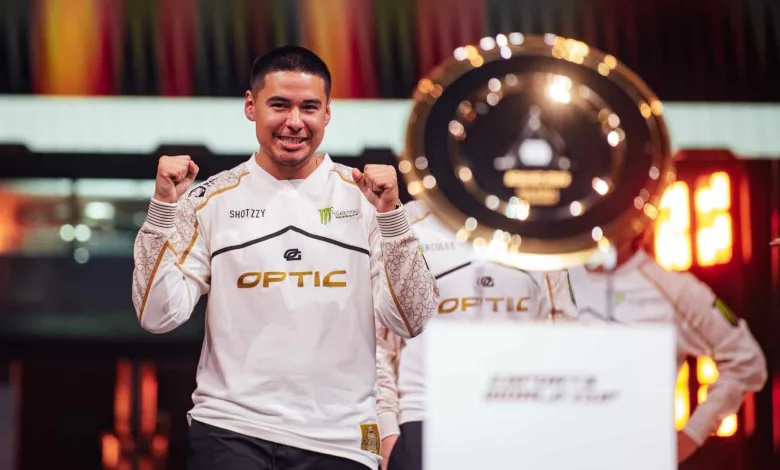 Shotzzy celebrates OpTic Gaming's Esports World Cup victory beside the tournament trophy