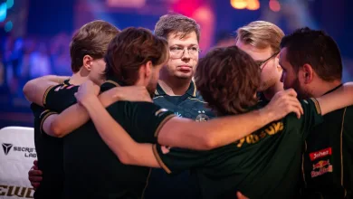 Counter-Strike esports players in dark jerseys huddle during the Esports World Cup 2026.