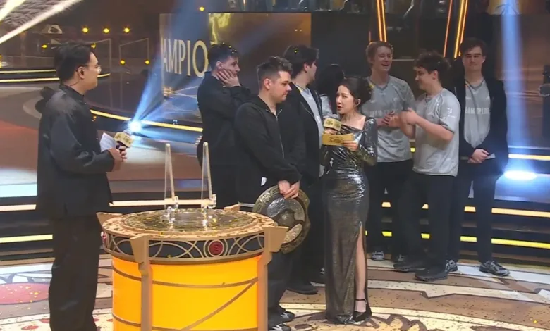 Team Spirit players gather onstage beside the championship trophy after winning The International 2026