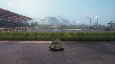 A World of Tanks vehicle sits on a paved area beside a racetrack-like circuit with mountains in the background.