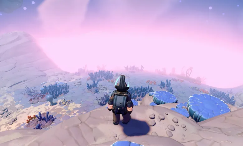A Young Suns character stands on a rocky moonlet overlooking blue alien plants beneath a pink sky.