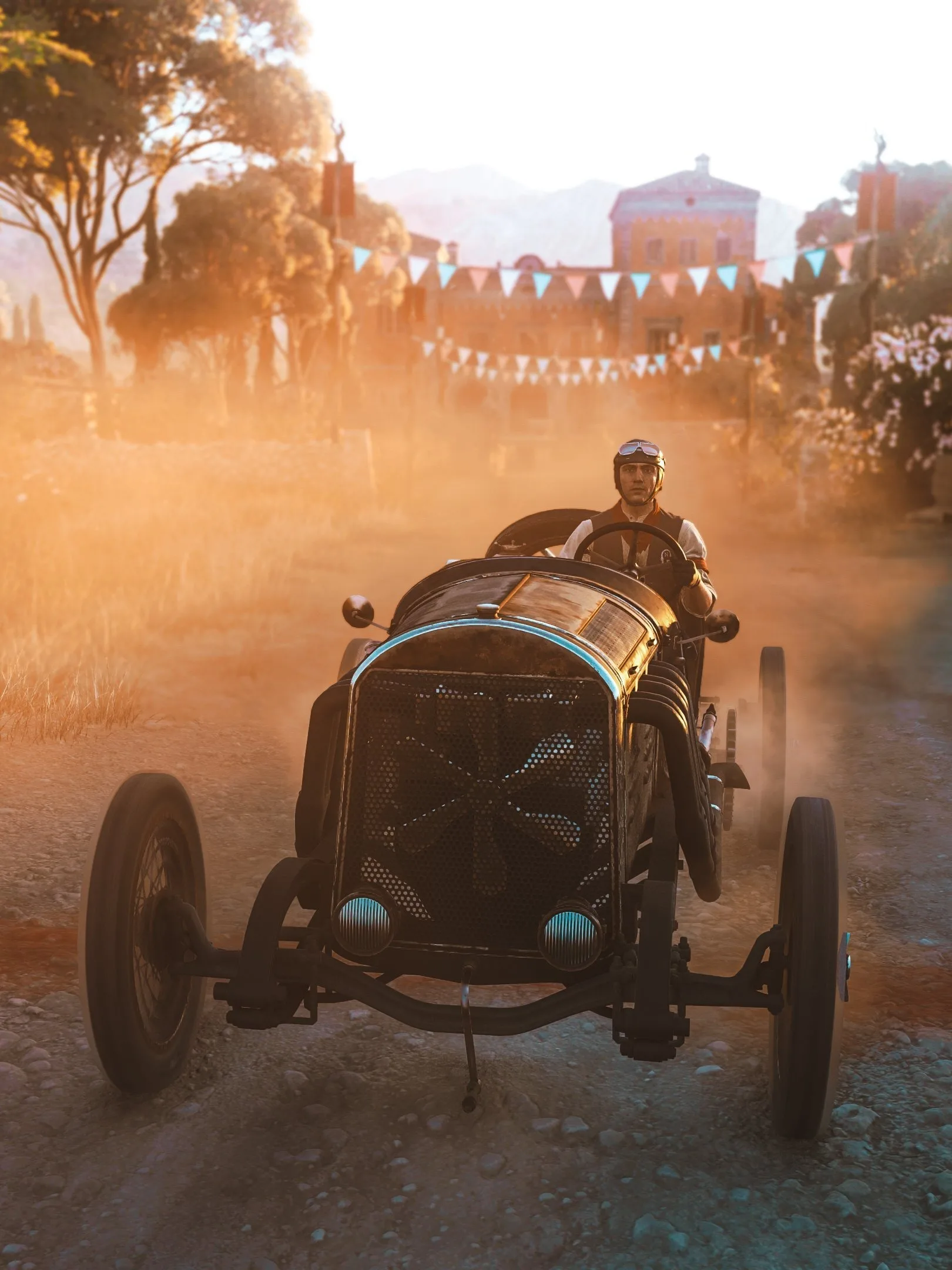 A vintage race car driving along a dusty road beneath colorful pennants