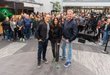 Asha Sharma stands with two Microsoft gaming leaders in front of a crowd at a public event.