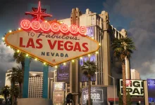 The Welcome to Fabulous Las Vegas sign and nearby buildings beneath a cloudy sky.