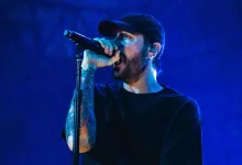 Benjamin Burnley sings into a microphone during a concert