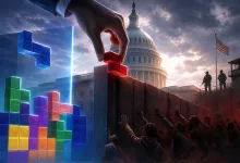 Tetris-like colored blocks rise beside a border wall beneath the U.S. Capitol dome, with a hand placing a red block and figures gathered in the foreground.