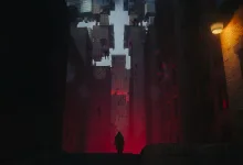A lone figure stands in a dark city street beneath suspended buildings and red light.