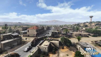 A wide view of Nasdara in DayZ Badlands shows a desert city, roads, and surrounding mountains.